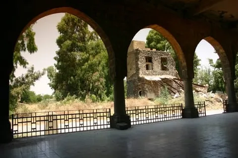 A ruined stone building framed by three arches