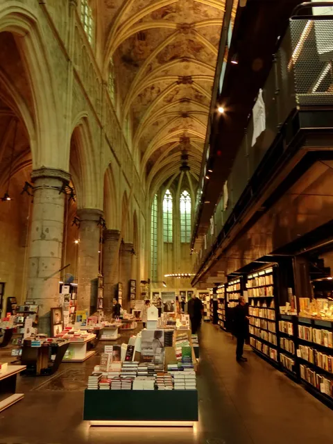 Bookshelves and tables inside a former church with tall vaulted ceilings