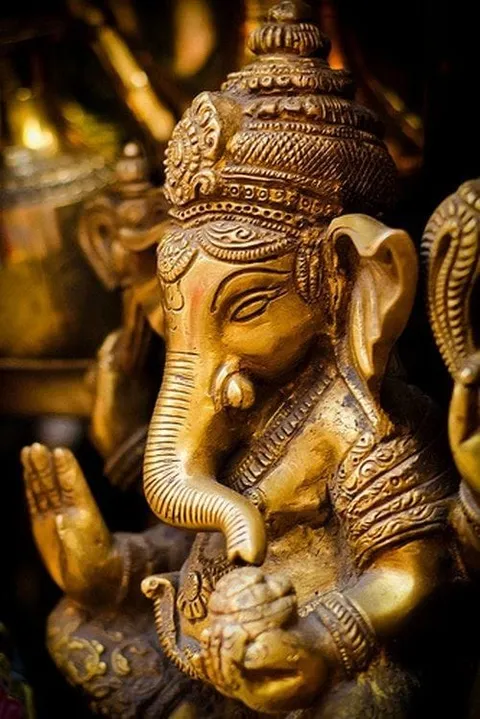 A golden statue of an elephant-headed deity with an ornate crown
