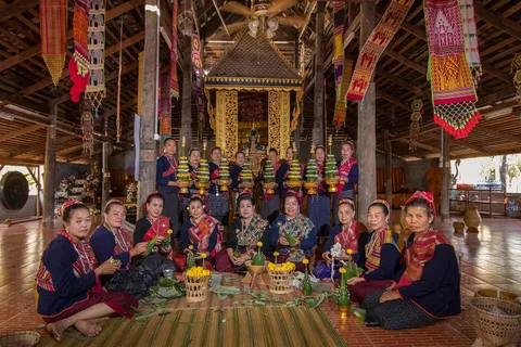 A group of women sitting together on mats inside a decorated temple