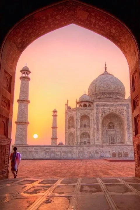 The Taj Mahal viewed through a large archway at sunset