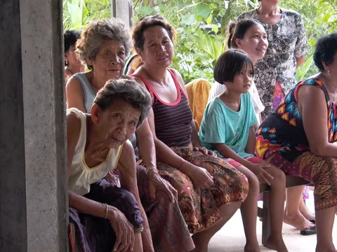 Women of several ages and a girl sitting together on a bench