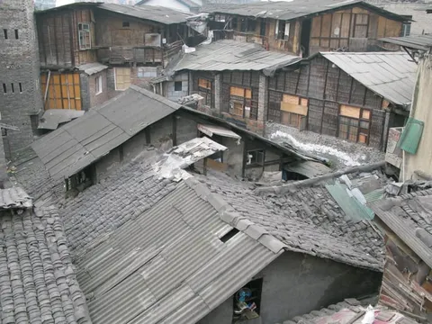 Closely packed tiled rooftops and wooden houses on a hillside