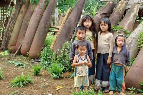 A group of children standing beside leaning wooden boards