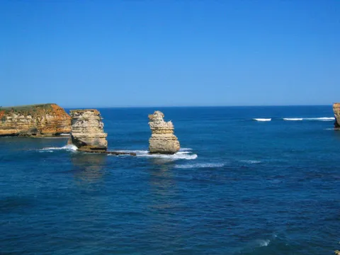 Two limestone rock stacks rising from a deep blue sea