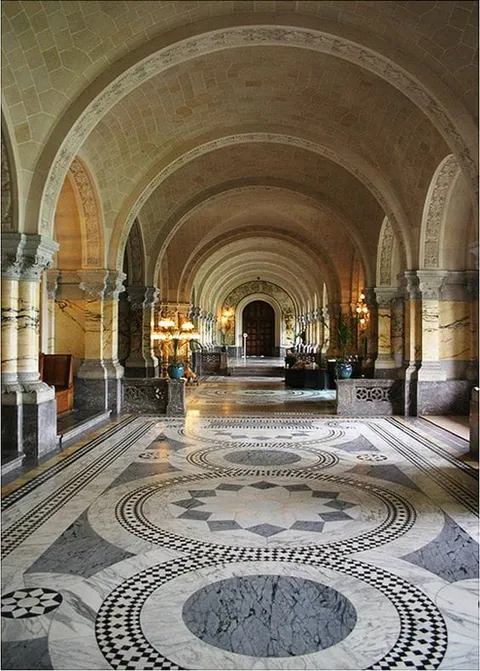 A long vaulted hall with columns and patterned stone floors