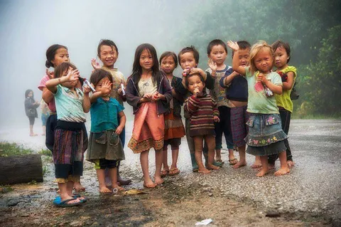 A group of children standing together and smiling outdoors