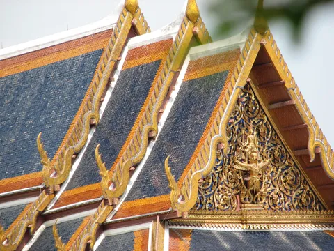 Steep temple roofs with blue tiles and ornate gold edging
