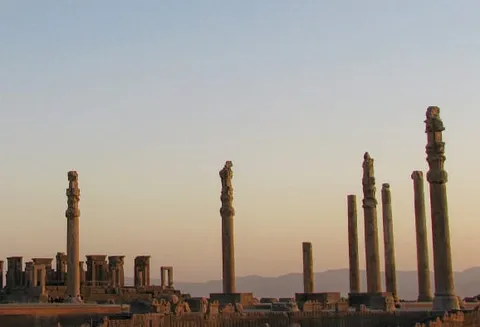 Rows of tall stone columns among ancient ruins