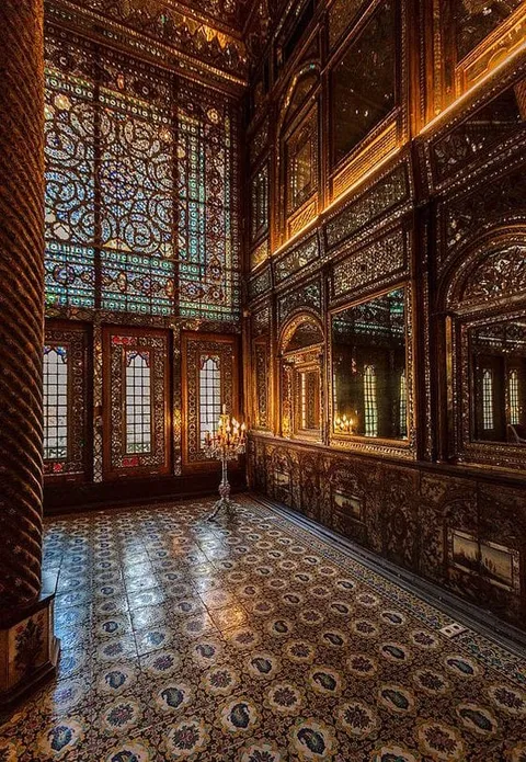 An ornate interior with patterned floors, tall windows and decorated walls