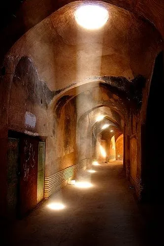 Sunlight falling through a roof opening into a vaulted stone passage