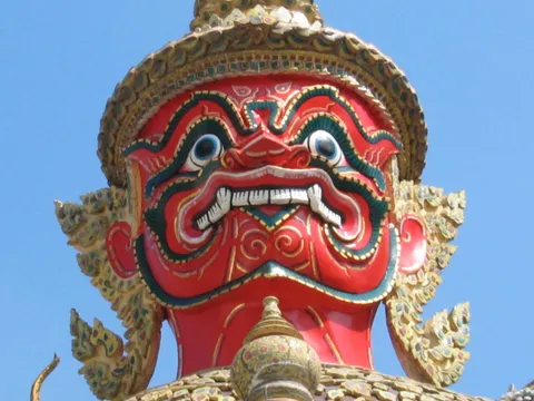 Close-up of a brightly painted guardian statue with an ornate gold headdress