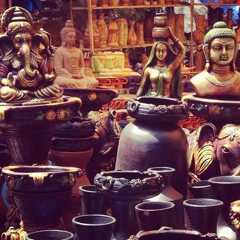 Metal vessels and statues displayed outside a shop