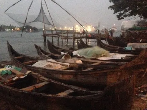 Fishing boats and large suspended fishing nets along the waterfront