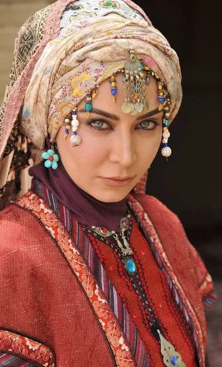 Portrait of a woman wearing a patterned head wrap and decorative jewellery