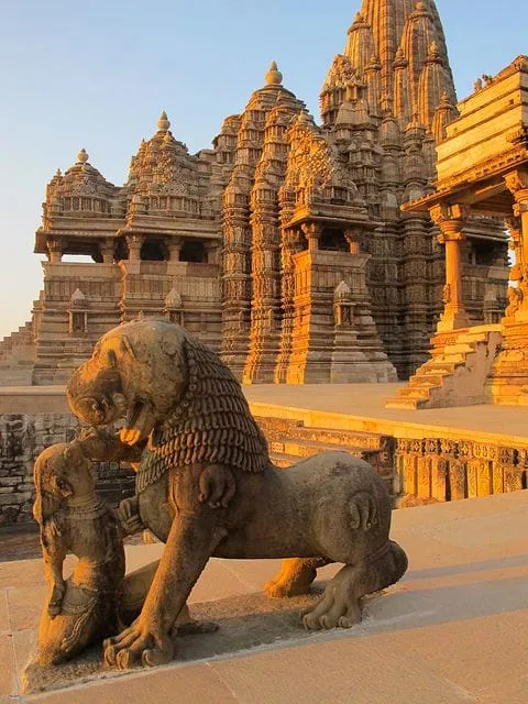 A carved stone lion standing outside an ornate temple