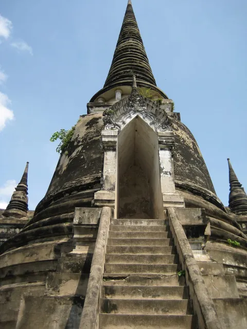 Steep stone steps leading up to a weathered bell-shaped stupa