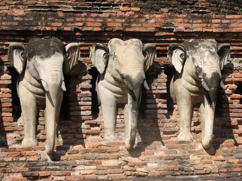 Stone elephant sculptures projecting from a brick temple wall