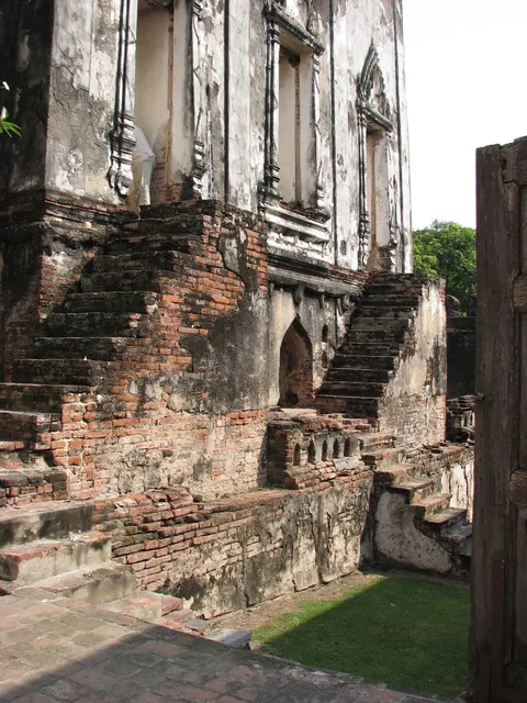 Brick temple ruins and a seated Buddha statue on a raised platform