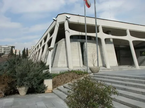 A large museum building with a flag above its entrance and steps in front