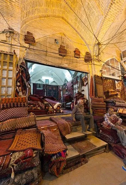 Rug-covered seating in a vaulted brick interior